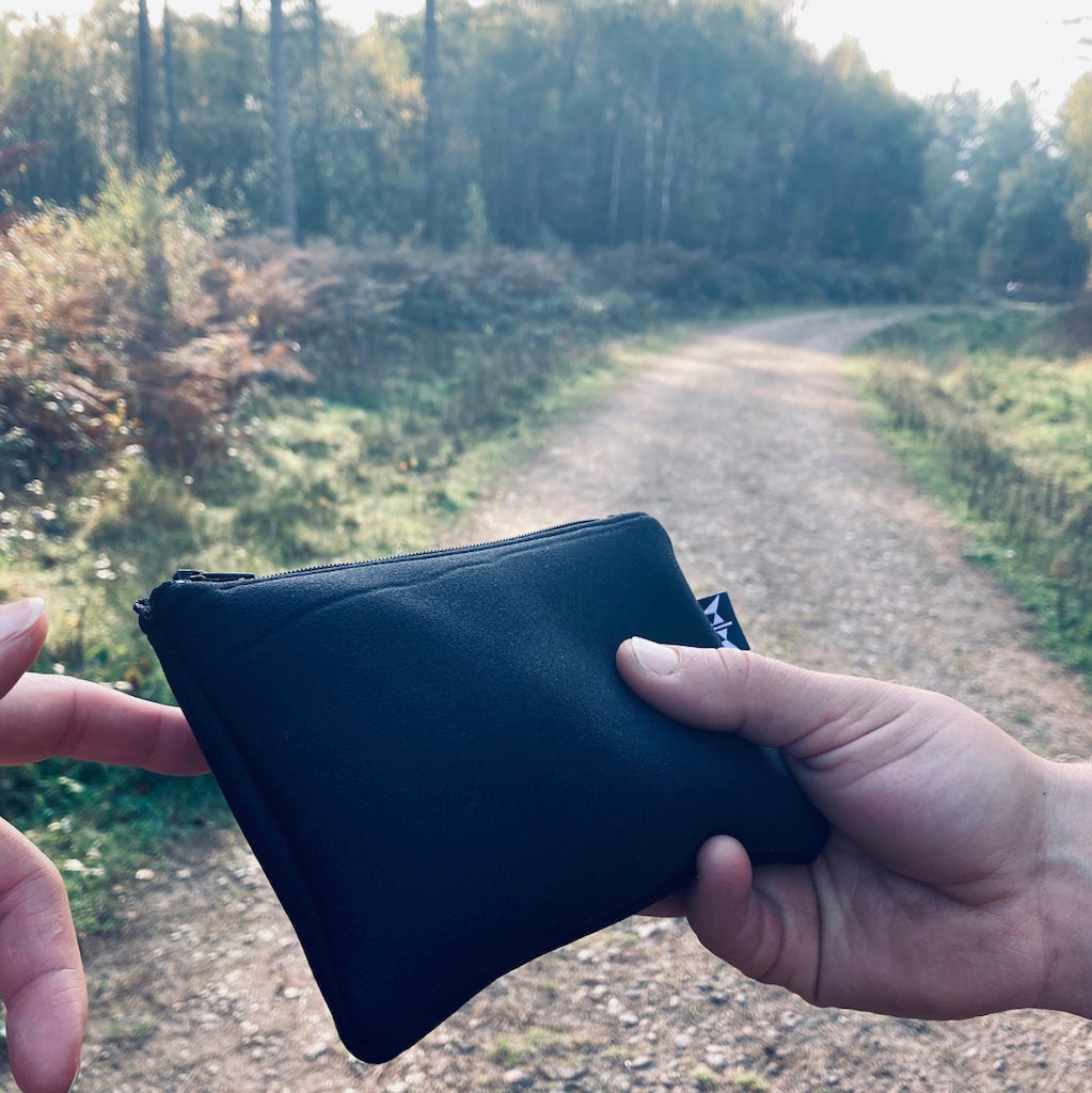 Earthbound Rectangle Neoprene Pouch in Black on a woodland walk