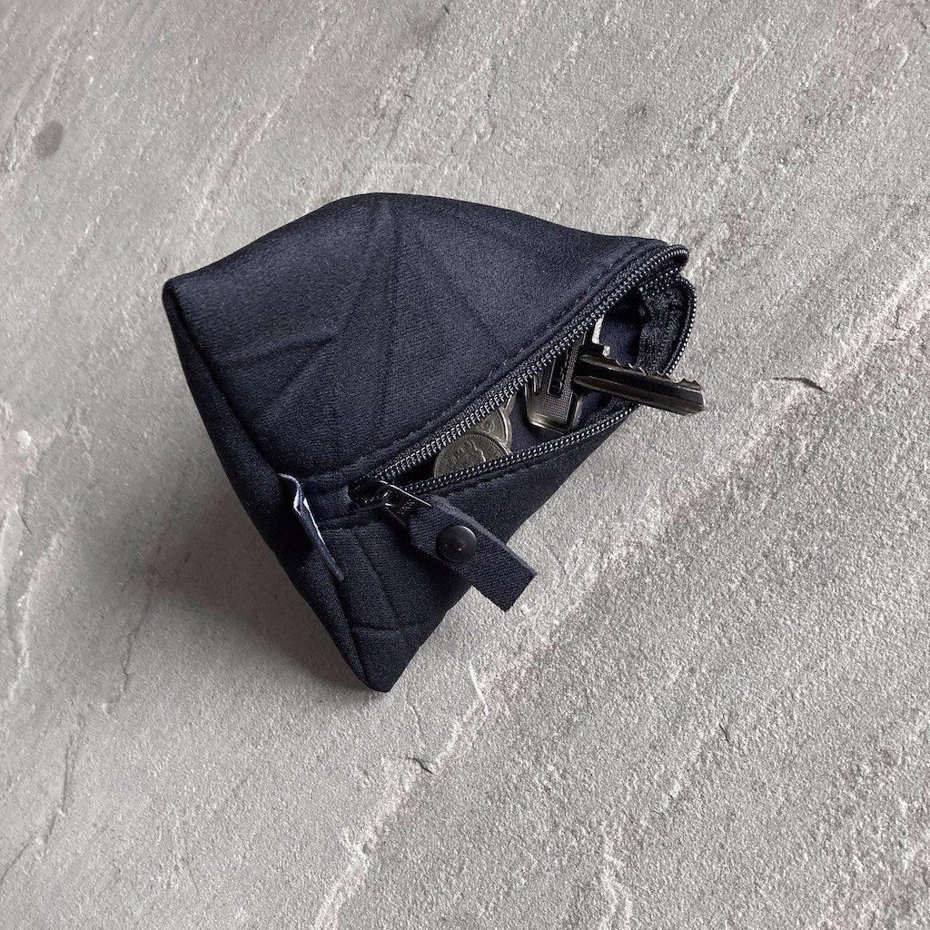 Trinity pyramid-shaped neoprene pouch in black with keys and coins inside